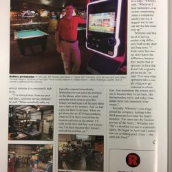 Jeff Whiteley standing next to arcade machine in newspaper article